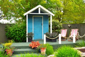 Photo of bright blue garden storage shed in cute garden